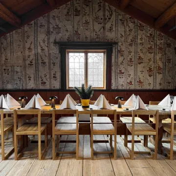 Uppdukat bord i rum med dalmålningar på väggen.