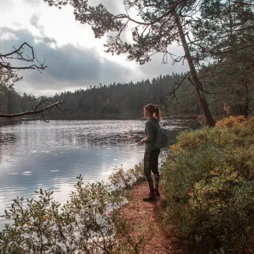 Kvinna vandrar vid en sjö.