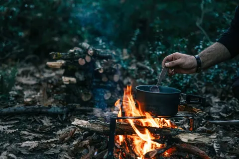 Matlagning i gryta över öppen eld i naturen.